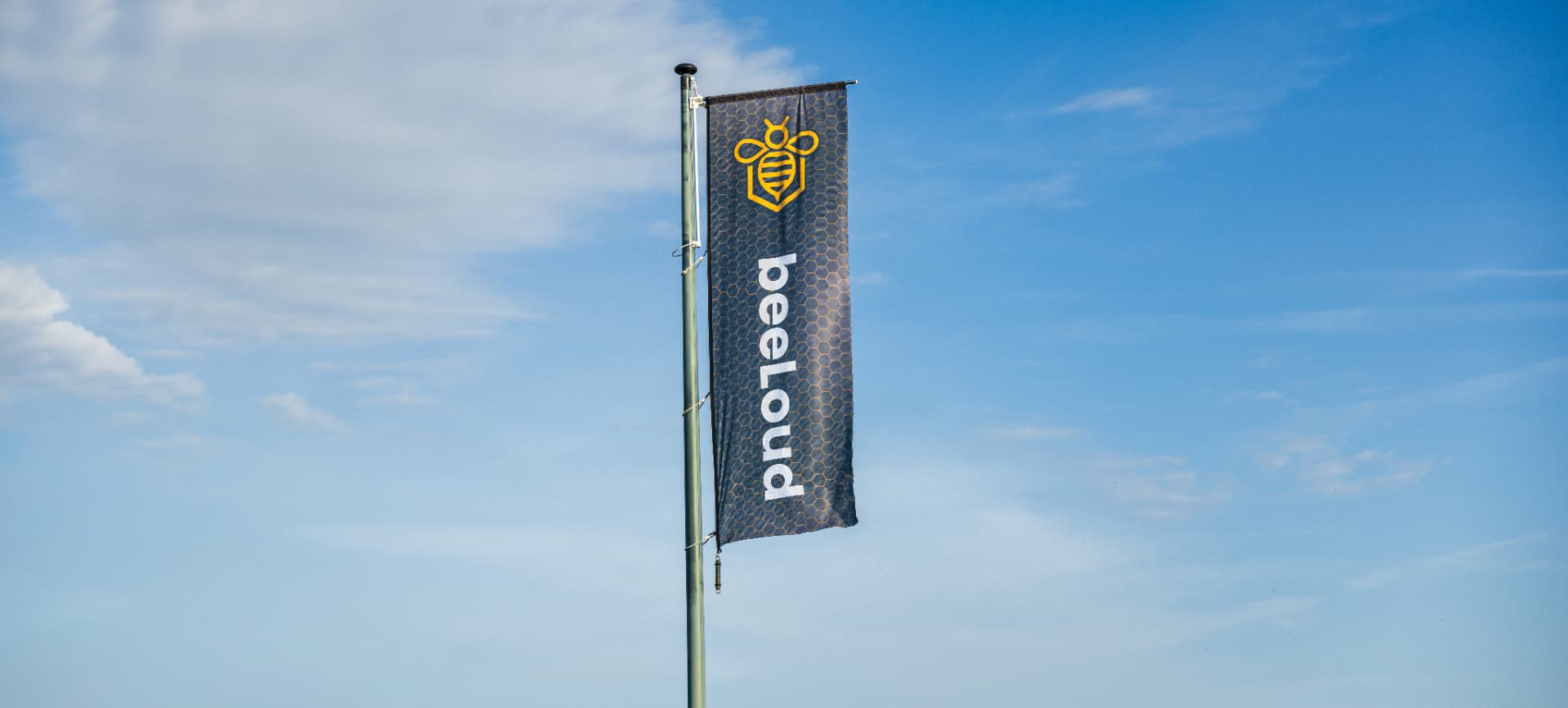 De beeLoud-vlag tegen een blauwe lucht boven Texel